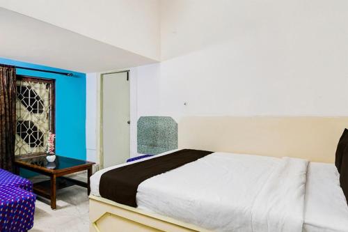 a bedroom with a large bed and a table at Hotel O Akash Namostay in Jamshedpur