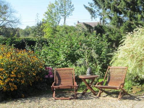 two chairs and a table in a garden at Domaine De La Carrauterie by Terre Insolite in Sautin