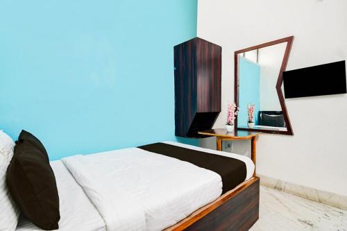 a bedroom with a bed and a mirror at Hotel O Akash Namostay in Jamshedpur