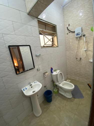 a bathroom with a sink and a toilet and a mirror at Merry in Kampala