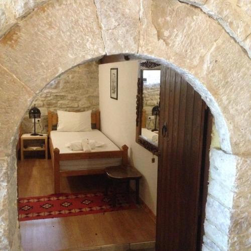 a room with a bed in a stone wall at Konaku Guest house in Gjirokastër