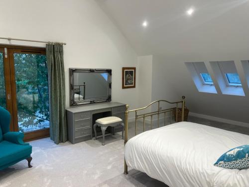 a bedroom with a bed and a tv and a chair at Glebe Barn in Cuxham
