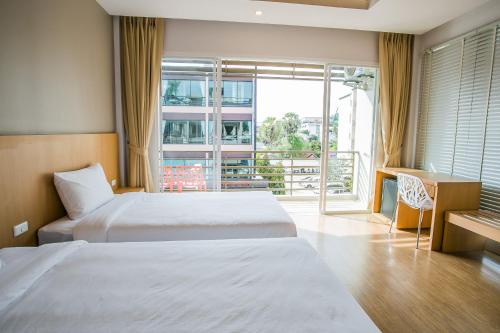 a hotel room with two beds and a balcony at Casa De Coral Boutique Hotel in Kata Beach