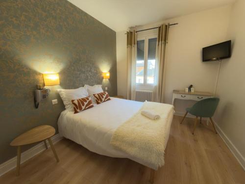a bedroom with a large bed and a television at Aux Vendanges de Bourgogne in Paray-le-Monial