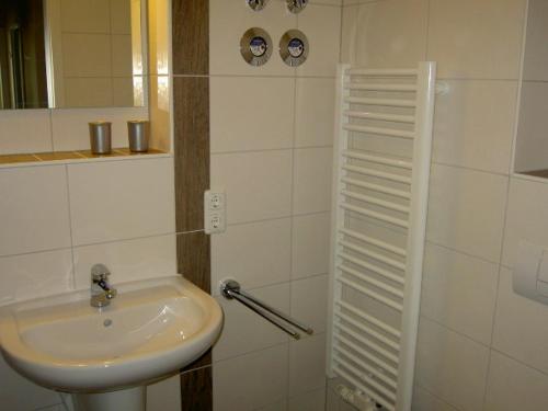 a white bathroom with a sink and a mirror at Ferienwohnung Rerik in Rerik