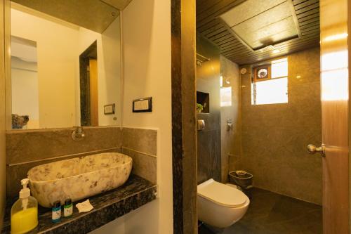 a bathroom with a large stone tub next to a toilet at Ragvi Resort Alibaug in Nagaon
