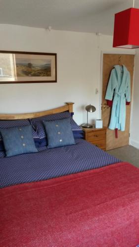 ein Schlafzimmer mit einem Bett und einem an der Wand hängenden Bademantel in der Unterkunft Podehole Bed and Breakfast in Spalding