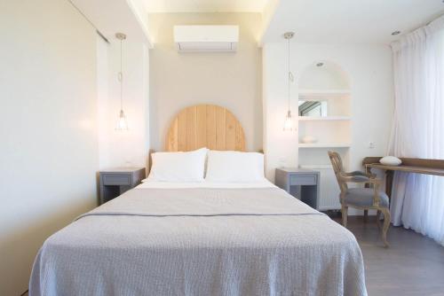a bedroom with a bed and a desk and a chair at PyleanBlue villas in Pylos