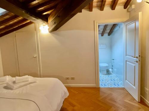 a bedroom with a white bed and a bathroom at Residenza Zaccone in Tivoli
