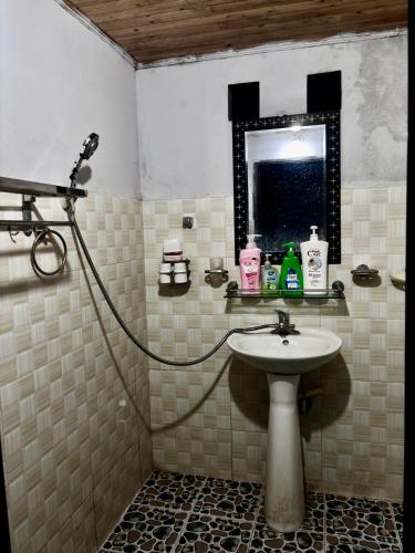 a bathroom with a sink and a mirror at Sisi House Experience Hike & Batik Painting in Sa Pả
