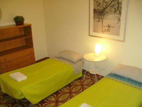 a bedroom with two beds and a table with a lamp at La Casa di Eva in Rome