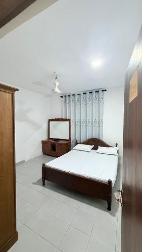 a bedroom with a bed and a mirror in it at Sunray Homes in Disagewatta