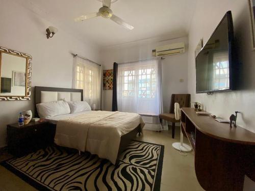 a bedroom with a bed and a desk and a sink at Suitehub in Ikeja