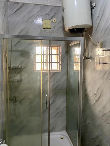 a bathroom with a shower and a glass shower backdoor at Suitehub in Ikeja