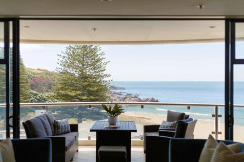 a living room with a view of the ocean at Oceanside Haven Resort with Luxury Sea Views in Mount Maunganui