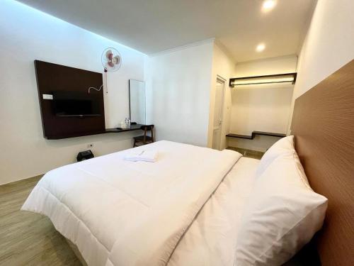 a bedroom with a white bed with a tv on the wall at The Royal Gisting - Heritage Hotel in Banjarnegeri