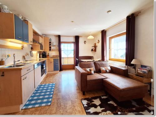 een keuken en woonkamer met een bank en een tafel bij Fewo-Egger-Thalmann in Virgen