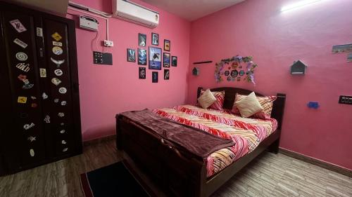 een slaapkamer met een bed in een roze kamer bij Maison De Ravi in Pondicherry