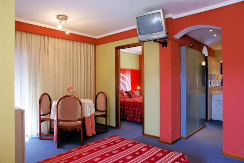 una habitación con una mesa y un televisor en la pared del Hotel Gran International de Villa Gesell