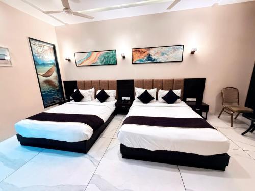 two beds in a hotel room with two beds at The Bhagwati Resort in Ābu Road