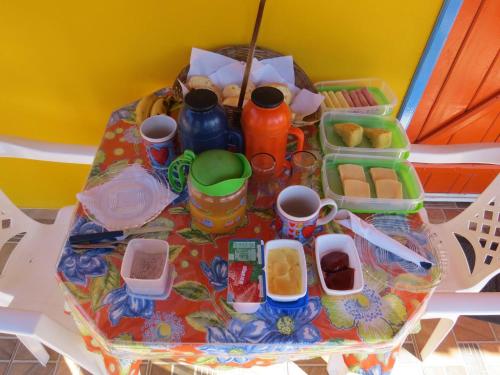 una mesa con una bandeja de comida y tazas. en Pousada Recanto do Sossego, en São Thomé das Letras