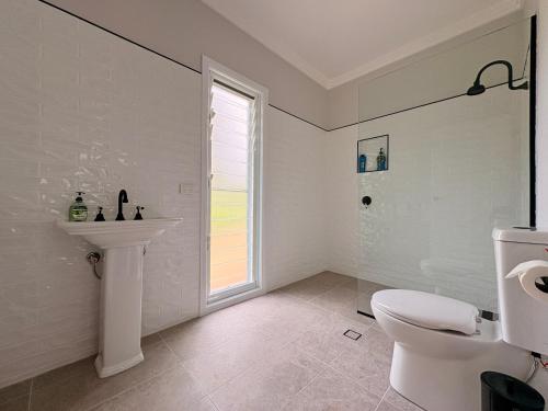 a white bathroom with a sink and a toilet at Casa Tranquilo in Kanighan
