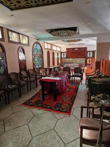 een kamer met een tafel en stoelen en een piano bij Café restaurant in Issafene