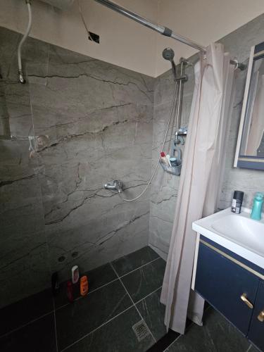 a bathroom with a stone shower and a sink at Kristina Guesthouse in Librazhd