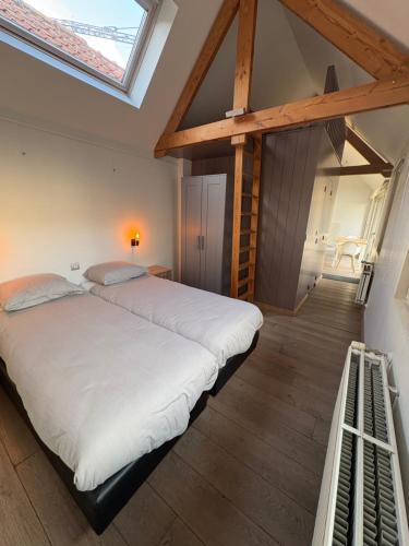a bedroom with a large white bed in a attic at Belle Nuit in Diksmuide