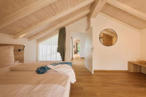 een slaapkamer met twee bedden en een spiegel aan de muur bij Kapfwald Appartements in Bad Dürrheim