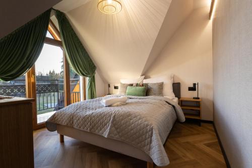 a bedroom with a bed and a large window at Olesiówka in Nowy Targ
