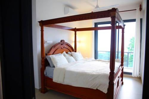 a bedroom with a wooden canopy bed with white pillows at Bustani Villa in Mchamba Wima