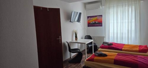 a room with two beds and a table and a desk at Berg Messe 5, w-lan, Homeoffice in Bergisch Gladbach