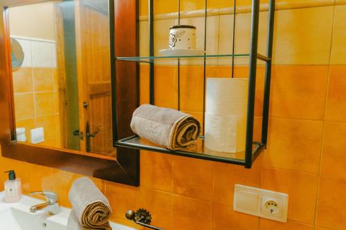 een badkamer met een wastafel, een spiegel en handdoeken bij La Huella del Cuero in Siles