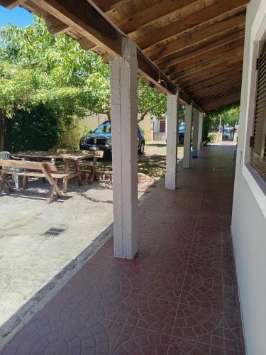 a covered porch with a picnic table and a car at Forza e avanti in Santa Teresita