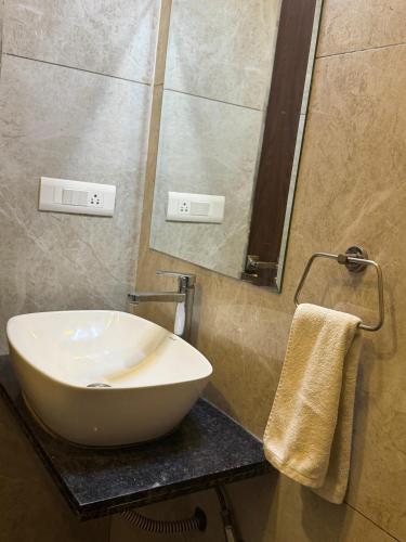 a bathroom with a white sink and a mirror at The Bhagwati Resort in Ābu Road