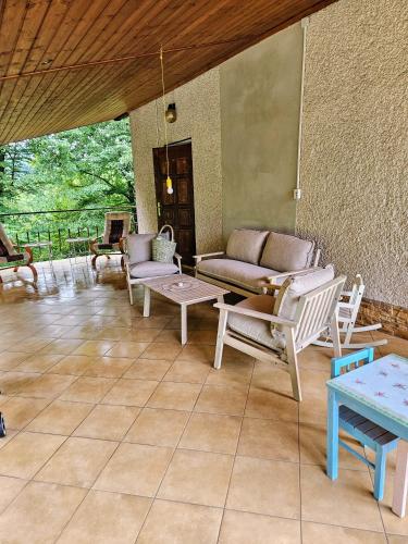 a patio with a couch and chairs and a table at Soliniany Zakątek in Solina