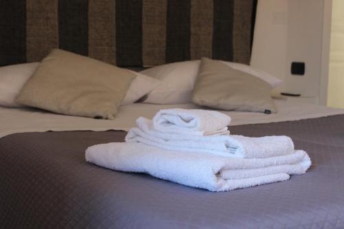 een stapel handdoeken bovenop een bed bij B&B MARIMA 2 POSTI ORGOSOLO in Orgosolo