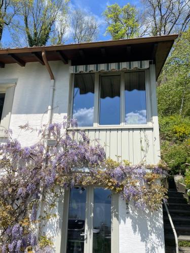 a house with a balcony with purple flowers on it at Lavaux Lodge - Romantic escape with magic views! in Chardonne