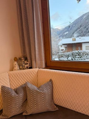 een bank met twee kussens voor een raam bij Hotel Garni Jennewein in Mayrhofen