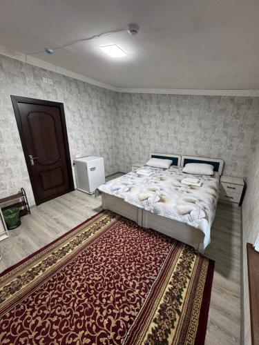 a bedroom with a large bed and a rug at Chorsu Old City in Tashkent