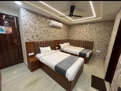 a bedroom with two beds and a ceiling fan at Hotel 24 STAR INN in Jāmb