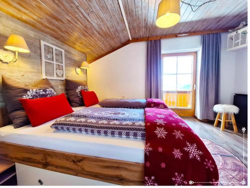 een slaapkamer met een bed met rode kussens bij Fewo-Egger-Thalmann in Virgen