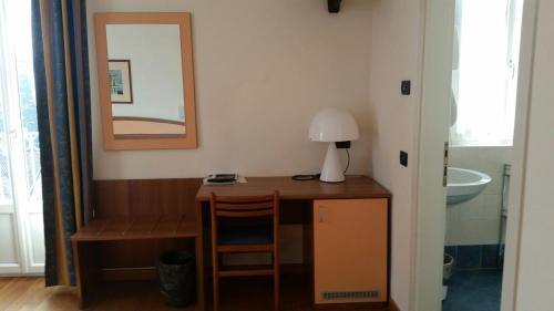 escritorio en una habitación con espejo y lavabo en Hotel Lario, en Mezzegra