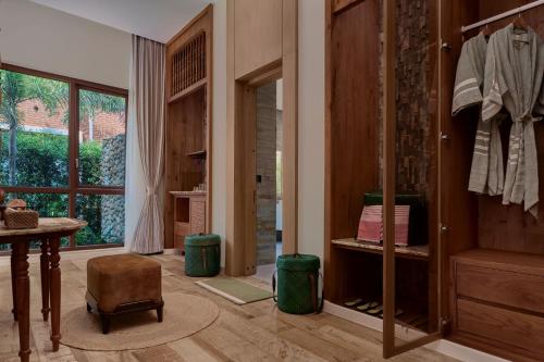 a room with a closet and a table and a window at Samanea Wellness Resort in Phumĭ Tŭk Lŭy