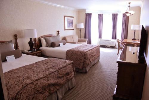 um quarto de hotel com duas camas e um sofá em Cow Hollow Inn and Suites em São Francisco