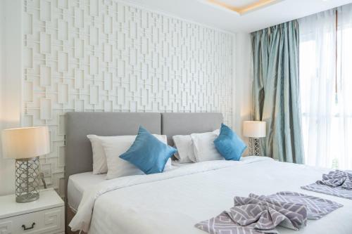 a bedroom with a large bed with blue pillows at Seavale patong phuket in Patong Beach