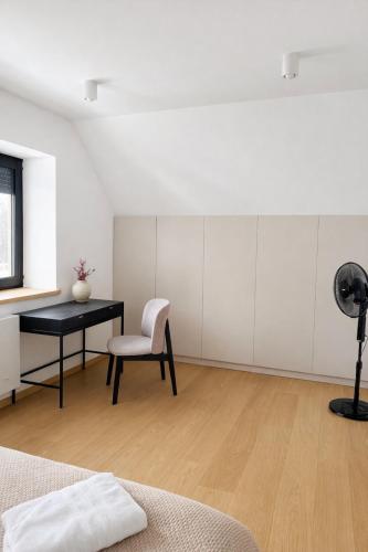 een slaapkamer met een bureau, een stoel en een tafel bij Willa Black Wood in Istebna