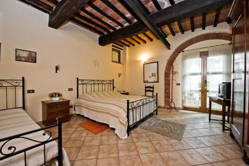 1 dormitorio con 1 cama y TV en Agriturismo Podere Fucile, en Montepulciano