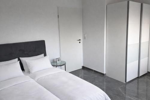 een slaapkamer met 2 witte bedden en een kast bij Luxus-Flat Wohnung-Hanau/Frankfurt in Hanau am Main